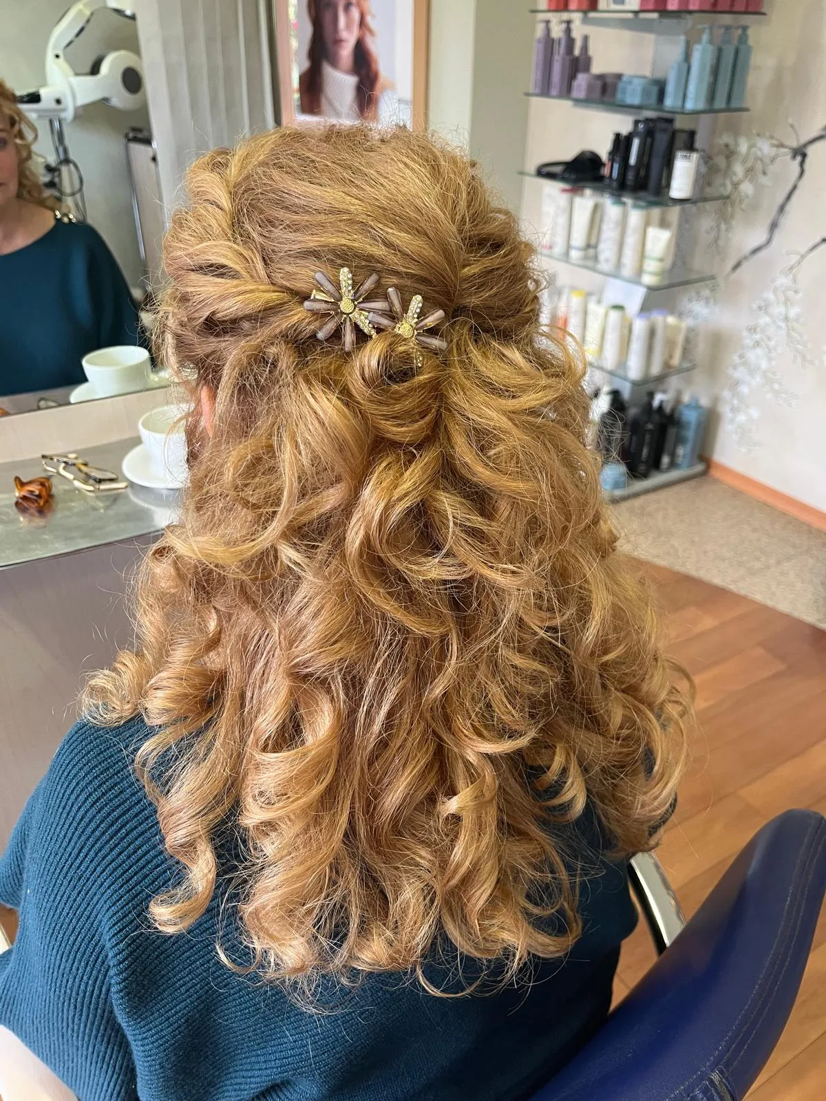 Halb hochgestecktes langes Haar mit Locken und zwei blütenförmigen Haarspangen von hinten